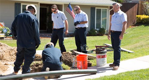 Lloyd's Plumbing technicians working in yard